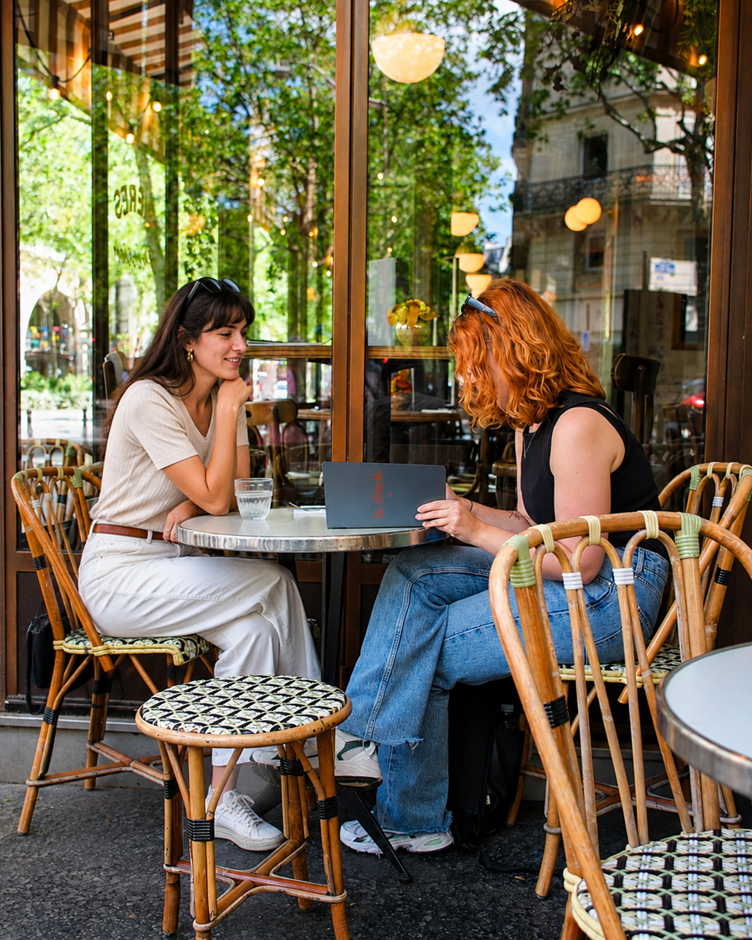 Terrasse des Affranchis avec tables rondes, chaises en rotin et végétation